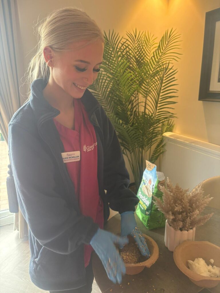 care home staff member planting seeds in a pot