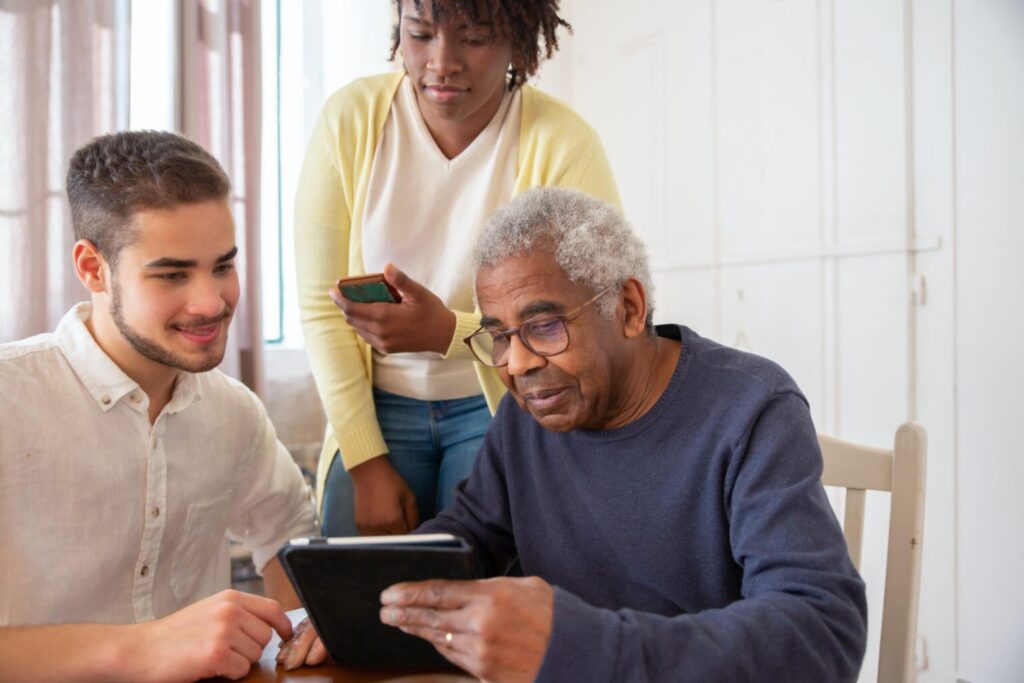 young man helping older people use a tablet