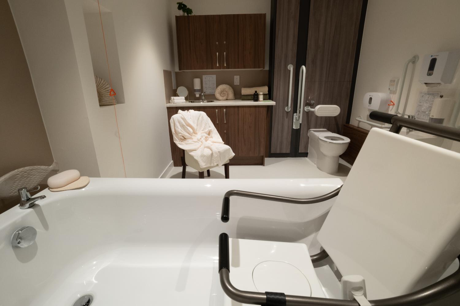 an accessible bath with handles in a care home