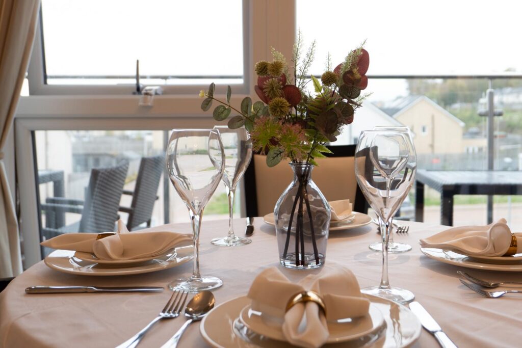dining room set with wine glasses and flowers