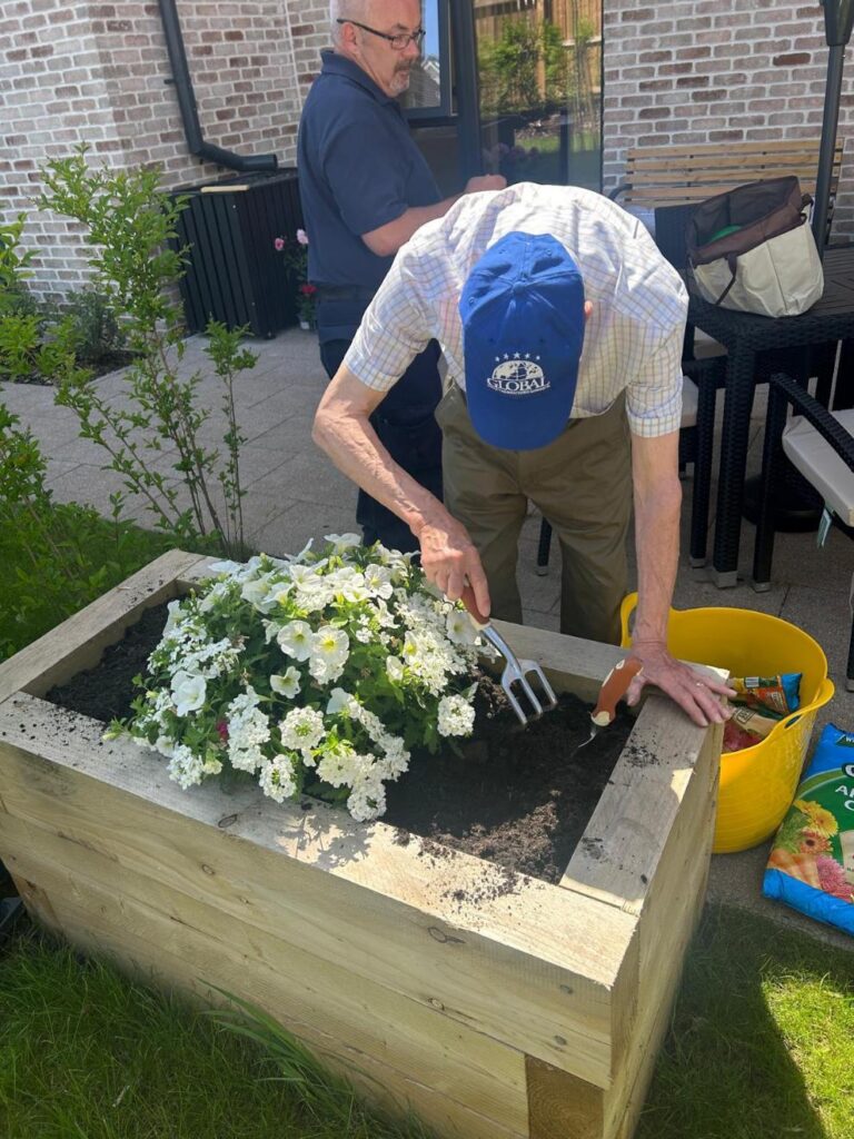 elderly man planting flowers