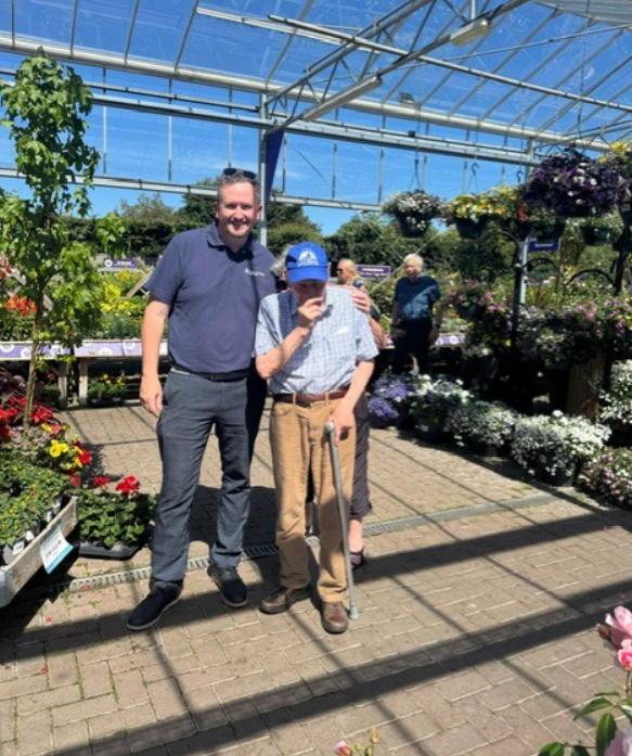 staff member standing in sunny garden with Bill
