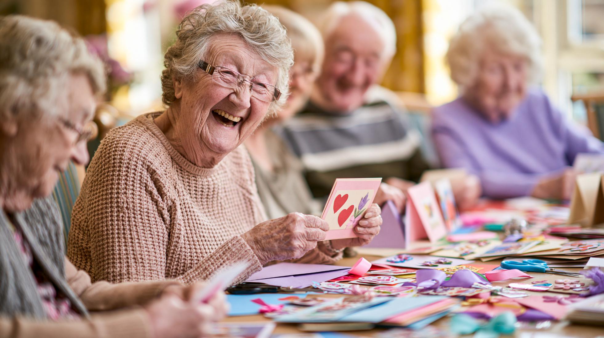 elderly woman laughing during a care home crafts activity