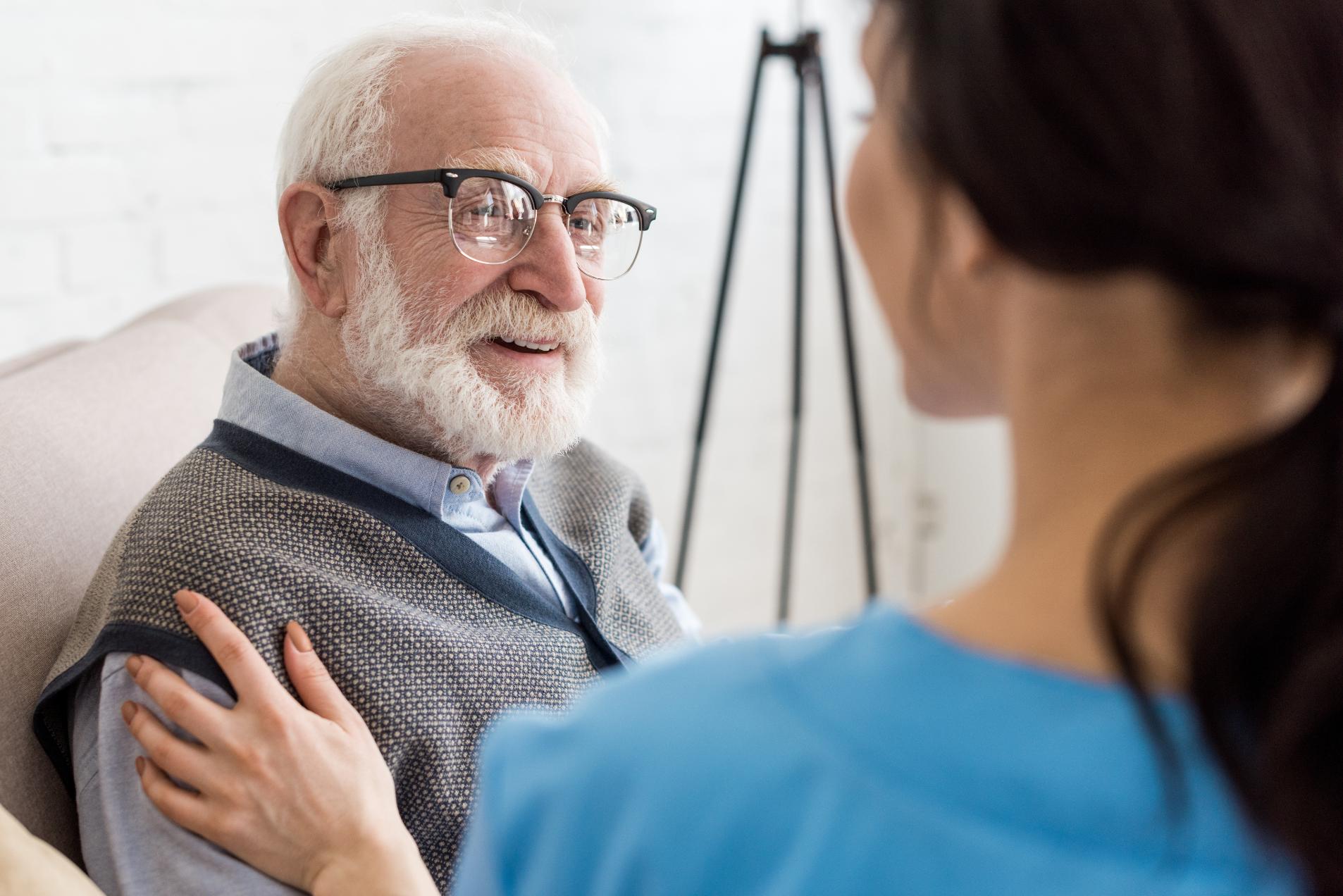 nurse with her hand on a resident's shoulder
